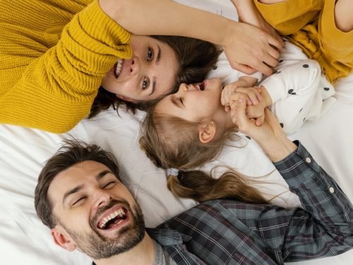 pais-e-filhos-em-filmagem-media-na-vista-de-cima-da-cama